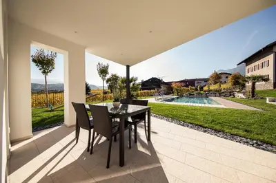a dining room with a table and chairs on a patio at Josefshof in Caldaro