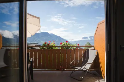 a view from a balcony with a chair and an umbrella at Haller Hof in Tirolo