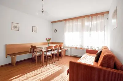 a living room with a couch and a table and chairs at Appartements Beikircher in Valdaora