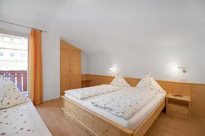 a bedroom with a large bed and a window at Appartements Beikircher in Valdaora