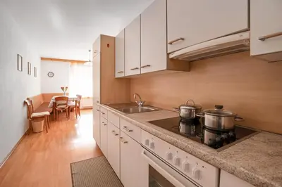 a kitchen with white cabinets and a stove top oven at Appartements Beikircher in Valdaora