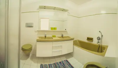 a bathroom with a sink and a toilet and a tub at Appartements Else in Ortisei