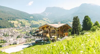 a wooden house on top of a hill at Boutique Hotel Pradell in Ortisei