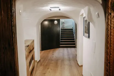a hallway with a black door and stairs in a house at Boutique Hotel Pradell in Ortisei