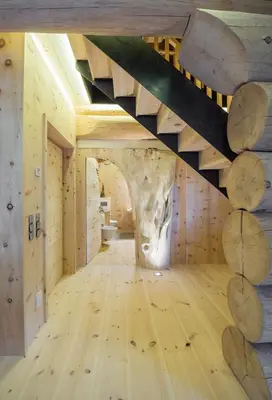 a staircase in a room with wooden floors and logs at Boutique Hotel Pradell in Ortisei