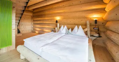 a bedroom with a bed in a log cabin at Boutique Hotel Pradell in Ortisei