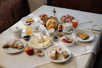 a table with breakfast foods and drinks on it at Boutique Hotel Pradell in Ortisei
