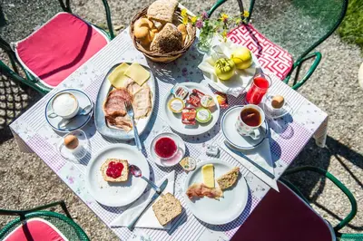 a table with plates of food and cups of coffee at Gasthaus Gasteiger in Lagundo