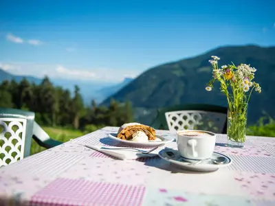 a table with a plate of food and a cup of coffee at Gasthaus Gasteiger in Lagundo