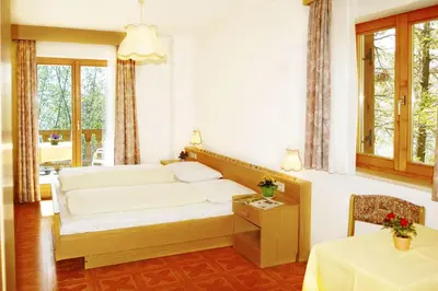 a bedroom with a bed and a table and a window at Gasthaus Gasteiger in Lagundo