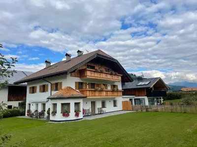 a large building with snow on the ground at App Unterhoezlhof in Valdaora