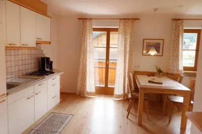 a kitchen with a table and a dining room at App Unterhoezlhof in Valdaora