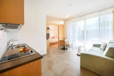 a kitchen and a living room with a couch at Arboris Appartement in Appiano sulla Strada del Vino