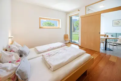 a bedroom with two beds and a dining room at Arboris Appartement in Appiano sulla Strada del Vino