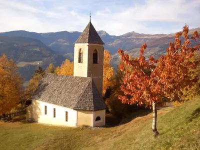 an old church on a hill with a tree at Solerhof in Laion