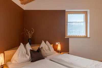 a bedroom with a bed with white pillows and a window at Solerhof in Laion