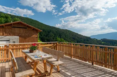 a wooden deck with a table and bench on it at Solerhof in Laion