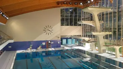 a large swimming pool with a clock on the wall at Nel Cuore Verde di Bolzano in Bolzano