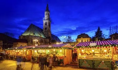 a christmas market in front of a church at night at Nel Cuore Verde di Bolzano in Bolzano