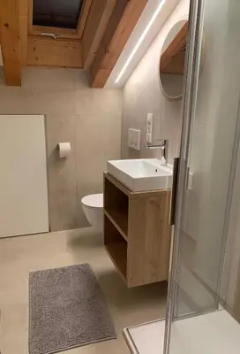 a bathroom with a sink and a toilet and a mirror at Ferienwohnung Eichnerhof in Magrè allʼ Adige