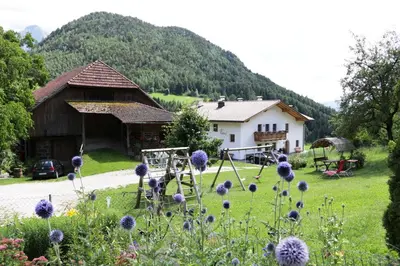 a bedroom with a large bed with white sheets at Paalhof in Castelrotto