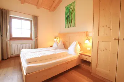 a large kitchen with wooden cabinets and a window at Paalhof in Castelrotto