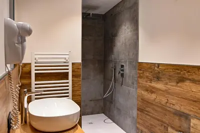 a bathroom with a white sink and a shower at Tilde in Tesero