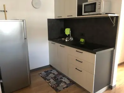 a kitchen with a refrigerator and a microwave at Tilde in Tesero