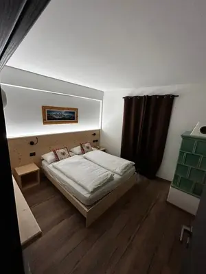 a small bedroom with a bed and a window at Tilde in Tesero