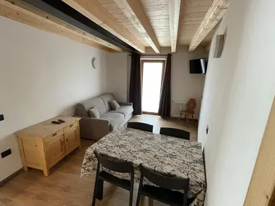 a living room with a table and a couch at Tilde in Tesero