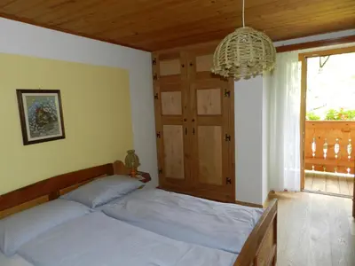 a bedroom with a bed and a window and a chandelier at Gedrarzerhof in Luson