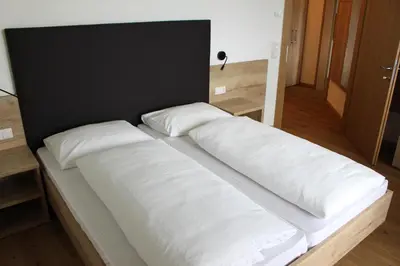 a room with a bed and a desk and a window at Gasthof Pizzeria Unterwirt in Collepietra