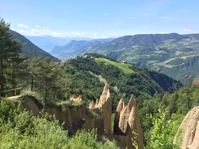 a village on a hill with mountains in the background at Gasthof Pizzeria Unterwirt in Collepietra