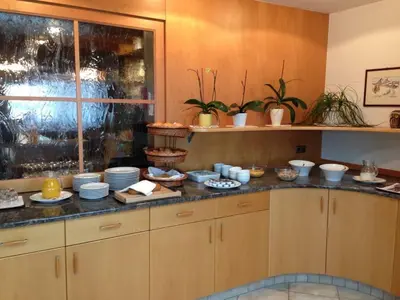 a kitchen with a counter with dishes on it at Gasthof Pizzeria Unterwirt in Collepietra