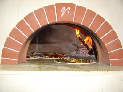 a pizza oven with two pizzas in it at Gasthof Pizzeria Unterwirt in Collepietra