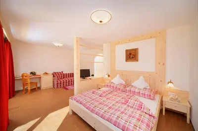 a bedroom with a bed and a desk at Leitenhof in Val di Vizze
