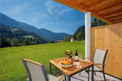 a table with a bowl of fruit and a bottle of wine at Leitenhof in Val di Vizze