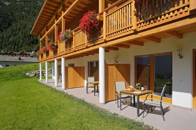 a balcony of a house with a table and chairs at Leitenhof in Val di Vizze