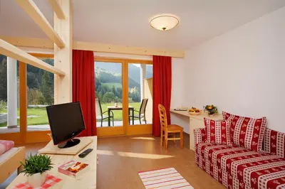 a living room with a couch and a table with a television at Leitenhof in Val di Vizze