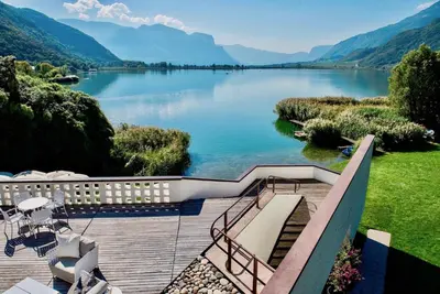 a view of a lake with mountains in the background at Seehotel Ambach in Caldaro