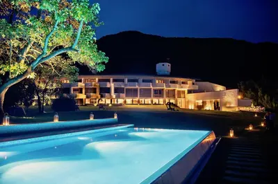 a building with a swimming pool in front of it at night at Seehotel Ambach in Caldaro