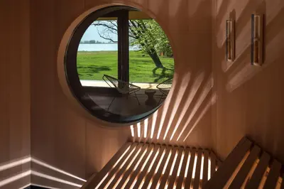 a room with a window and a bench with a mirror at Seehotel Ambach in Caldaro