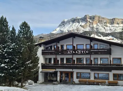 a large building with a mountain in the background at Pension Atlantic in Badia