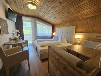 a bedroom with a bed and a couch and a table at Pension Atlantic in Badia