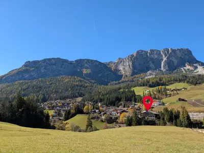 a red kite flying over a village in the mountains at Pension Atlantic in Badia
