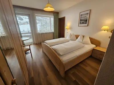 a bedroom with a bed and a table and window at Pension Atlantic in Badia