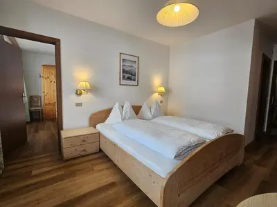 a bedroom with a large bed with white sheets at Pension Atlantic in Badia