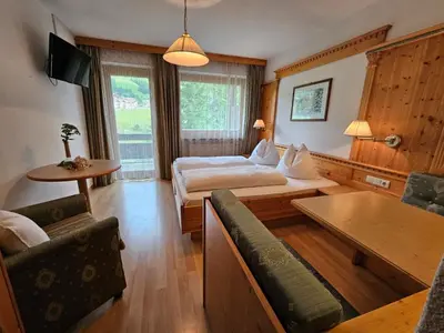 a hotel room with a bed and a couch at Pension Atlantic in Badia