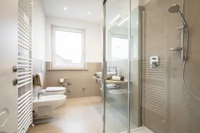 a bathroom with two toilets and a glass shower at Fior Apartments in Merano