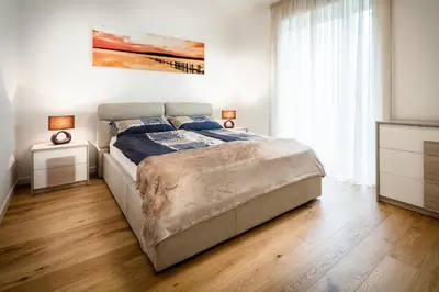 a bedroom with a bed and a painting on the wall at Fior Apartments in Merano